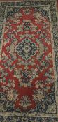 Two modern machine made rugs with Persian style decoration on a red ground, within a red,