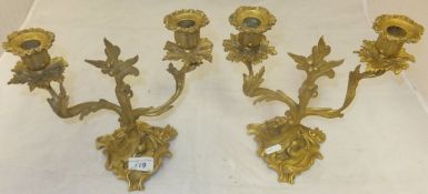 A pair of ormolu twin branch candelabra with all-over foliate decoration in the Rococo taste