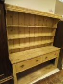 A Victorian pine dresser of three open shelves above a base of two deep drawers,