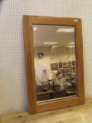An oak framed rectangular bevel-edged wall mirror