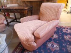A pair of deep seated Victorian chairs in the Howard manner, with pale peach chequered upholstery,