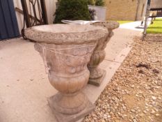 A pair of composite stone garden urns CONDITION REPORTS There are several chunks