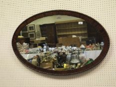 A 20th Century mahogany framed oval wall mirror