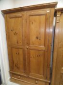A vintage two door pitch pine wardrobe with single drawer,