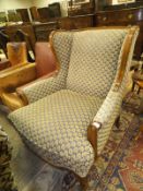 A Wesley Barrell stained beech framed wing back armchair in the Louis XV taste