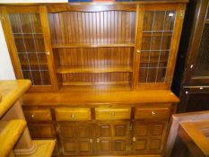 A modern oak and elm dresser with two leaded glazed doors and two shelves over four drawers and