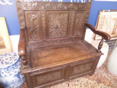 A carved oak bench with panelled back and lift top seat CONDITION REPORTS Has