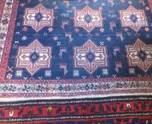 An Afghan tribal rug, the centre field with repeating star medallions in red,