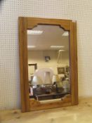 An oak framed rectangular wall mirror with shaped frame