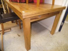 A modern rectangular light oak draw leaf dining table on square supports