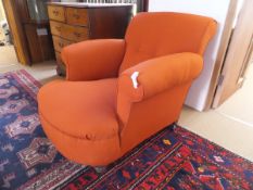 A deep seated Howard style armchair in terracotta upholstery,