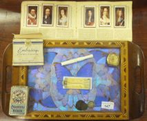 A marquetry inlaid and butterfly wing decorated tray, various cigarette cards,