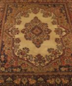 A Tabriz carpet, the central floral decorated medallion in terracotta, salmon,