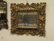 A 19th Century carved and giltwood framed rectangular wall mirror in the Rococo taste with bevel