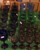 A selection of various suites of coloured glasses to include blue, green,