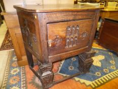 A carved oak credence style cupboard with single door,