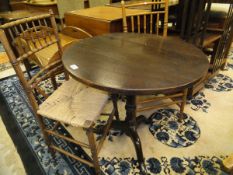 A 19th century circular oak snap-top table on single turned column to tripod base,