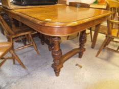 A Victorian oak extending dining table, the top with rounded corners,