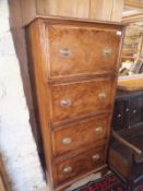 A walnut cross-banded narrow chest four deep drawers with applied moulding oval drop handles and