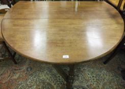 A mahogany oval gate-leg dining table with baluster turned and ringed legs