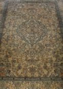 A Persian silk rug, the central medallion in cream, peach and blue,