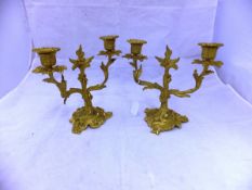 A pair of ormolu twin branch candelabra with all-over foliate decoration in the Rococo taste