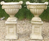 A pair of composite stone plant pots in the Greco Roman taste,