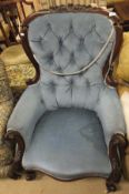 A Victorian button back upholstered tub chair, raised on turned and ringed legs,