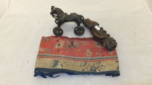 A box containing a Peruvian style metal horse figure on wheels,