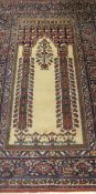 A Persian prayer rug, the central panel decorated in dark blue, cream, burgundy, green,