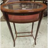 An oval glass topped bijouterie table on slender square sectioned legs,