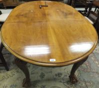 An early to mid 20th Century oval walnut extending dining table,