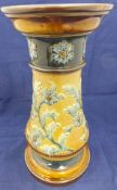 A Doulton Lambeth stoneware jardinier stand decorated with flowers and foliage in blues and greens