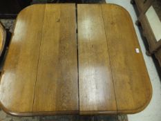 A Victorian oak extending dining table, the top with rounded corners,