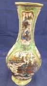 A Chinese porcelain vase with polychrome decoration panels of pagodas in a landscape on a celadon