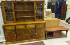 A modern oak and elm dresser with two leaded glazed doors and two shelves over four drawers and