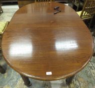 An oval mahogany extending dining table raised on turned and reeded legs to castors,