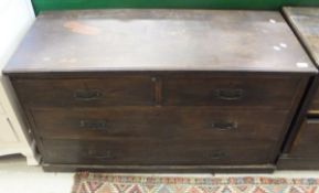 An early 20th Century stained beech low chest of two short over two long drawers,