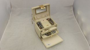 A cream jewellery box containing a large collection of costume jewellery to include earrings, etc,