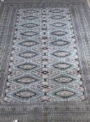 A Turkish rug, the central diamond shaped medallions in pale blue, pale gold, cream,