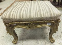 A 19th Century square gilt decorated footstool in the Louis XVI taste with acanthus carved cabriole