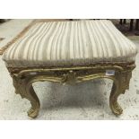 A 19th Century square gilt decorated footstool in the Louis XVI taste with acanthus carved cabriole