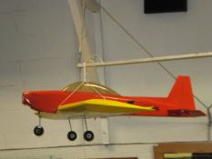 A large red and yellow model monoplane with winged scull and crossbones motif (no engine)