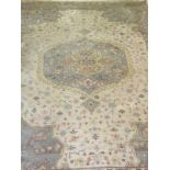An Indian rug, the central medallions in cream, pale sand, pale blue, pale yellow and pale salmon,