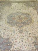 An Indian rug, the central medallions in cream, pale sand, pale blue, pale yellow and pale salmon,