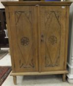 A modern Indonesian hardwood two door cupboard with carved decoration