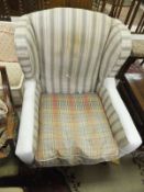 A 19th Century style wing back armchair upholstered in cream and pale grey striped fabric,