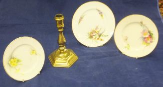 Three various Worcester floral spray painted plates and an 18th Century brass candlestick of