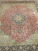 An Iranian Kashan carpet, the central floral medallion in dark blue, cream, pink,