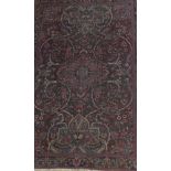 A Persian rug, the central floral medallion in blue, burgundy,